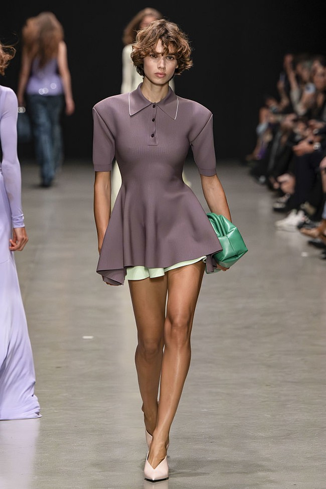 Beberapa potongan tampil mencolok, seperti baby-doll dress dengan bordir biru dan tutu rajut merah yang memiliki lebar ekstrem — seolah sulit melewati pintu. Namun di Paris, tempat semangat Marie Antoinette masih hidup, kembalinya siluet rok lebar tampak sangat relevan. (Foto: Victor VIRGILE/Gamma-Rapho via Getty Images)