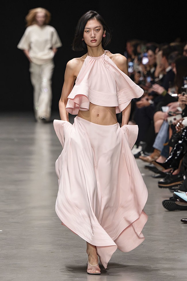 Ia menggabungkan struktur korset klasik dan bahu skulptural dengan jaket bergaya maskulin khasnya, bahkan menerapkannya pada gaun mini dengan rok krinolin. (Foto: Victor VIRGILE/Gamma-Rapho via Getty Images)