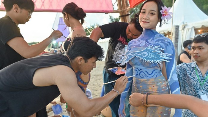 Seniman melukis pada tubuh model dalam rangkaian Sanur Village Festival 2025 di Denpasar, Bali, Sabtu (8/11/2025). Kegiatan itu diselenggarakan untuk mengapresiasi kreativitas puluhan seniman dari berbagai komunitas seni sekaligus menjadi daya tarik bagi para wisatawan yang berkunjung ke kawasan wisata Sanur. ANTARA FOTO/Fikri Yusuf/nym.