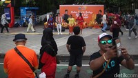 Para seniman gambang kromong dan pemain barongsai bergantian menghibur warga yang melintas saat Hari Bebas Kendaraan Bermotor (HBKB) di kawasan Dukuh Atas, Jakarta, Minggu (9/10/2025).