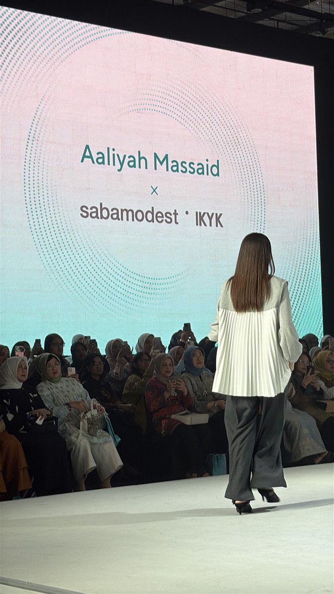 Aaliyah Massaid terlihat berjalan tegak menampilkan keseluruhan busana detail belakang two-tone abu-abu dan hitam. Pilihan warna monokromatik yang netral menegaskan kesan sophisticated dan timeless. Foto: Dok. Jakarta Muslim Fashion Week (JMFW) 2026.