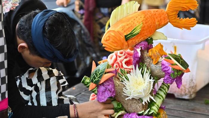 Peserta merangkai buah dan sayuran yang telah diukir saat mengikuti lomba mengukir buah di Sanur, Denpasar, Bali, Minggu (9/11/2025). Lomba rangkaian Sanur Village Festival 2025 tersebut diselenggarakan untuk mengenalkan potensi kawasan wisata Sanur khususnya keindahan lautnya melalui media buah dan sayuran lokal. ANTARA FOTO/Fikri Yusuf/sgd