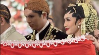 Mereka melakukan prosesi sinduran. Dalam prosesi ini, kedua mempelai pria dan wanita diselimuti bagian punggungnya menggunakan kain sindur yang biasanya berwarna merah dan putih. Kain merah melambangkan keberanian dan cinta, sedangkan warna putih melambangkan kesucian dan kemurnian. Foto: Instagram @shabrinaaluna