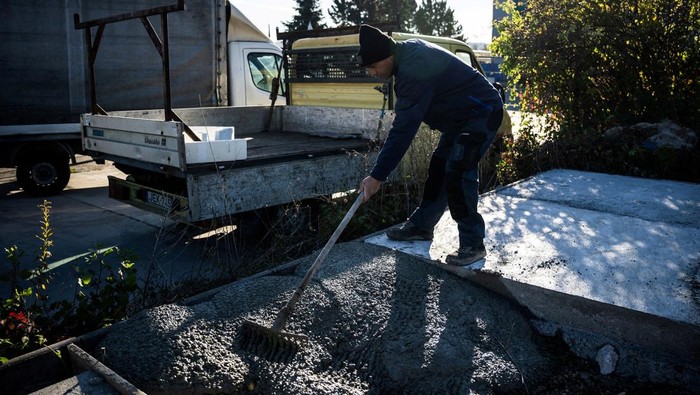 A worker puts plastic into a grinder to make crushed plastic at an industrial site in Tatabanya, Hungary, October 20, 2025. Budapest-based Makropa says it uses a proprietary powdered additive and standard mixing gear to bind shredded mixed waste into a lightweight concrete called Waste Light Concrete, or WLC. REUTERS/Marton Monus