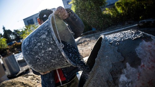 A worker puts plastic into a grinder to make crushed plastic at an industrial site in Tatabanya, Hungary, October 20, 2025. Budapest-based Makropa says it uses a proprietary powdered additive and standard mixing gear to bind shredded mixed waste into a lightweight concrete called Waste Light Concrete, or WLC. REUTERS/Marton Monus