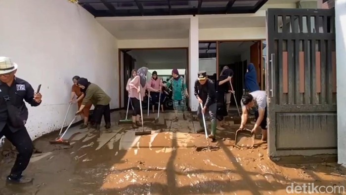 Warga Bumiayu bersama petugas gabungan bersih-bersih lumpur sisa banjir bandang, Minggu (9/11/2025).