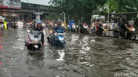 Ketinggian air di lokasi mencapai lutut orang dewasa, membuat puluhan sepeda motor mogok.
