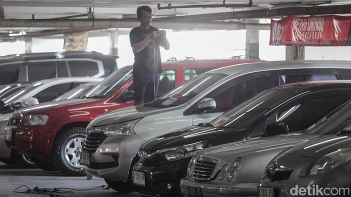 Pekerja membersihkan kendaraan bekas di kawasan Kebayoran Baru, Jakarta, Senin (10/11/2025). Bea balik nama mobil bekas sudah tak dikenakan biaya lagi. Buat kamu yang baru beli mobil bekas dan mau balik nama, ini merupakan kesempatan emas. Sebab, biaya yang dikeluarkan jadi lebih ringan.