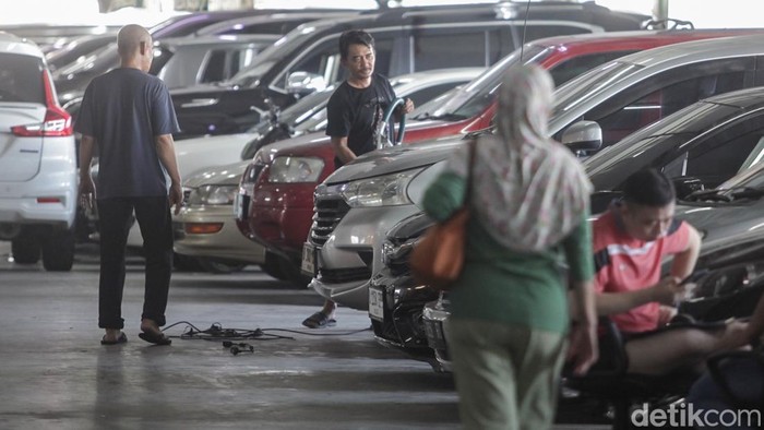 Pekerja membersihkan kendaraan bekas di kawasan Kebayoran Baru, Jakarta, Senin (10/11/2025). Bea balik nama mobil bekas sudah tak dikenakan biaya lagi. Buat kamu yang baru beli mobil bekas dan mau balik nama, ini merupakan kesempatan emas. Sebab, biaya yang dikeluarkan jadi lebih ringan.