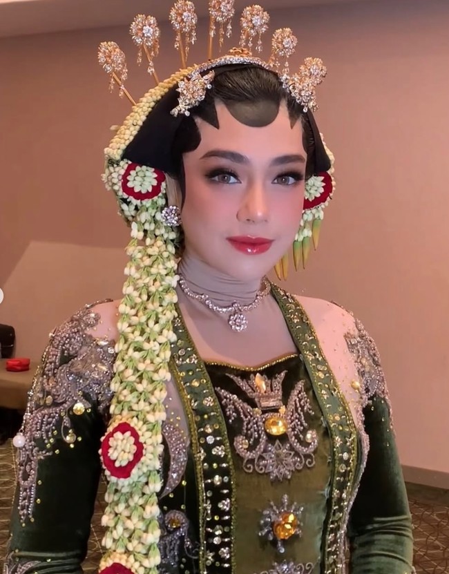 Penampilan Celine Evangelista kembali mencuri perhatian publik. Kali ini, aktris cantik tersebut tampil memesona dalam balutan busana pengantin adat Jawa. Menariknya, meski mengenakan paes dan sanggul khas pengantin Jawa, Celine tetap menutup aurat dengan gaya berhijab yang elegan. Foto: Instagram/@hepidavid
