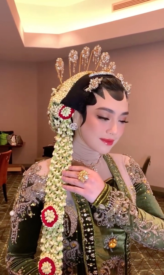 Yang paling menarik, Celine tetap mengenakan hijab tipis berwarna nude yang dililit rapi di leher, menutupi hingga bagian telinganya tanpa mengganggu bentuk paes maupun hiasan kepala. Pilihan warna nude yang senada dengan kulit membuat hijab yang dikenakannya hampir tak terlihat. Foto: Instagram/@hepidavid