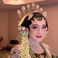 Wanita 33 tahun itu mengenakan kebaya beludru berwarna hijau lumut rancangan Wicaksono Aji yang dihiasi detail bordir dan payet keemasan di seluruh permukaannya. Aksen manik-manik dan motif tradisional di bagian dada hingga lengan memberi kesan glamor namun tetap anggun khas pengantin Jawa klasik. Foto: Instagram/@hepidavid