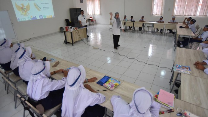 Pegawai Kementerian Keuangan (Kemenkeu) memasang tanda pengenal siswa saat program Kemenkeu Mengajar di Sekolah Rakyat 4 Padang, Sumatera Barat, Senin (10/11/2025). Program tersebut merupakan kegiatan mengajar satu hari pegawai Kemenkeu dengan memberikan pembelajaran kepada siswa/i terkait peran Kementerian Keuangan dalam upaya menjaga ekonomi negeri, serta memperkenalkan profesi, nilai-nilai kebaikan, dan semangat yang ada di Kementerian itu.  ANTARA FOTO/Iggoy el Fitra