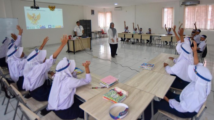 Pegawai Kementerian Keuangan (Kemenkeu) memasang tanda pengenal siswa saat program Kemenkeu Mengajar di Sekolah Rakyat 4 Padang, Sumatera Barat, Senin (10/11/2025). Program tersebut merupakan kegiatan mengajar satu hari pegawai Kemenkeu dengan memberikan pembelajaran kepada siswa/i terkait peran Kementerian Keuangan dalam upaya menjaga ekonomi negeri, serta memperkenalkan profesi, nilai-nilai kebaikan, dan semangat yang ada di Kementerian itu.  ANTARA FOTO/Iggoy el Fitra