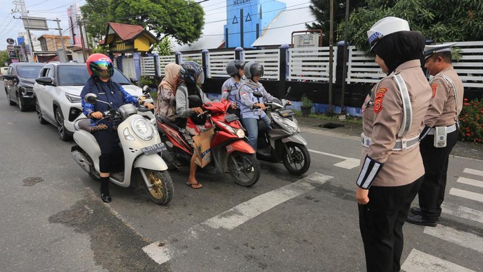 Personel Satlantas Polres Aceh Barat bersama sejumlah pengguna jalan mengheningkan cipta di jalan Imam Bonjol Simpang Kisaran Meulaboh, Aceh Barat, Aceh, Senin (10/11/2025). Kegiatan mengheningkan cipta selama satu menit tersebut untuk memperingati, mendoakan dan mengenang jasa para pahlawan yang telah gugur dalam perjuangan merebut dan mempertahankan kemerdekaan Indonesia. ANTARA FOTO/Syifa Yulinnas