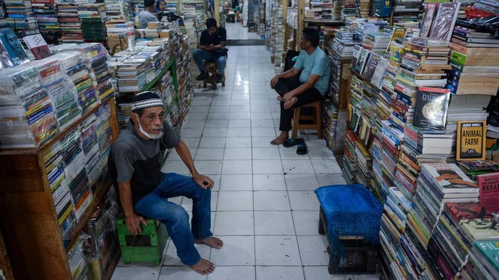 Pedagang menunggu pembeli di Pasar Buku Kwitang, Jakarta, Minggu (9/11/2025). Menurut pedagang penjualan buku di pasar tersebut saat ini menurun hingga 90 persen dibandingkan sebelum masa pandemi covid-19 karena masyarakat banyak beralih membeli buku digital dan melakukan transaksi pembelian buku fisik secara daring. ANTARA FOTO/Putra M. Akbar
