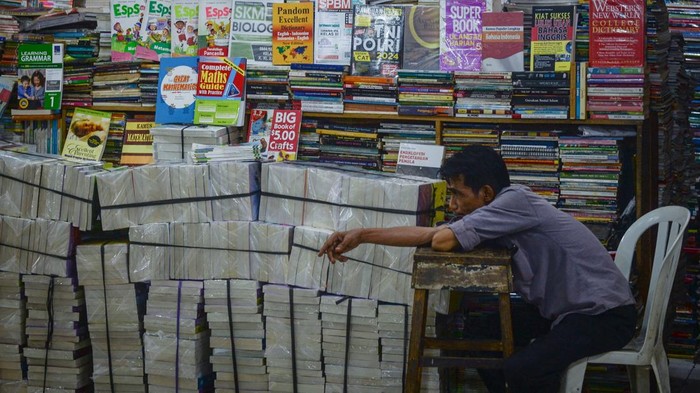 Pedagang menunggu pembeli di Pasar Buku Kwitang, Jakarta, Minggu (9/11/2025). Menurut pedagang penjualan buku di pasar tersebut saat ini menurun hingga 90 persen dibandingkan sebelum masa pandemi covid-19 karena masyarakat banyak beralih membeli buku digital dan melakukan transaksi pembelian buku fisik secara daring. ANTARA FOTO/Putra M. Akbar