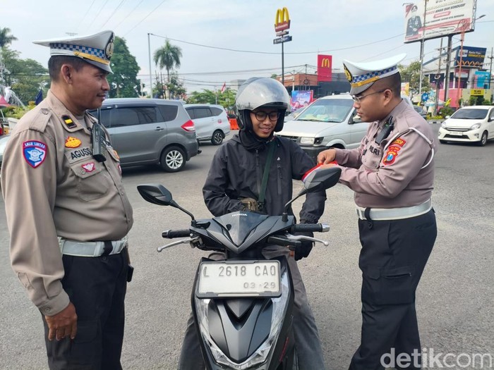 Pengendara di Sidoarjo diberi bendera saat peringatan Hari Pahlawan