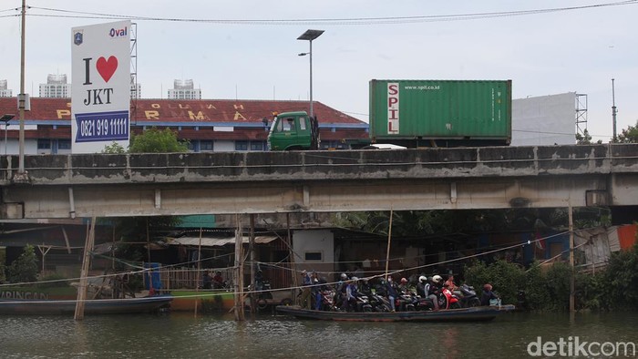 Sejumlah pengendara sepeda motor menggunakan perahu eretan menyeberangi Sungai Kali Cagak di Kecamatan Penjaringan, Jakarta, Senin (10/11/2025). Warga memanfaatkan jasa penyeberangan perahu eretan untuk memangkas jarak hingga 7 km dengan mengurangi waktu tempuh pada jam macet mencapai 30 menit. Setiap pengendara dikutip tarif Rp 2.000 untuk sekali jalan.  Perahu eretan ini menghubungkan Kapuk Muara di sisi barat dengan Muara Karang hingga Pluit di sisi timur.  Perahu tersebut beroperasi sejak pukul 03.00 WIB hingga 22.00 WIB.