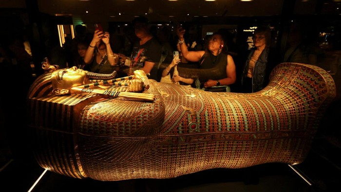 Visitors look at the golden coffin of ancient Egyptian Pharaoh Tutankhamun during the first day for visitors after the official opening of the Grand Egyptian Museum (GEM), near the Giza pyramid complex, in Giza, Egypt, November 4, 2025. REUTERS/Mohamed Abd El Ghany