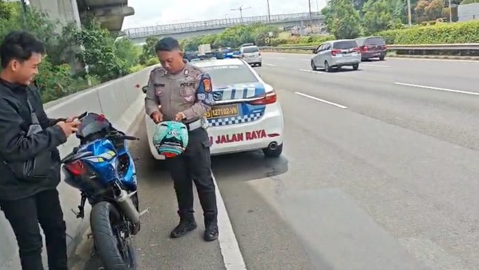 Polisi menindak pengendara motor yang nyelonong masuk Tol Cililitan.