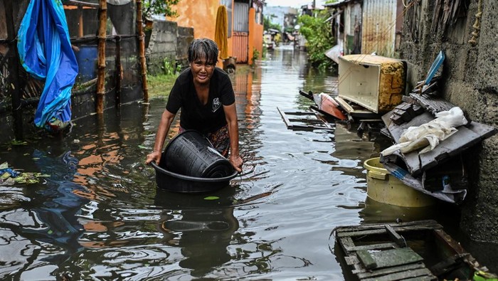 A woman wades through a flooded alley after Typhoon Fung-wong hit Dagupan City, Pangasinan, Philippines, November 10, 2025. REUTERS/Noel Celis