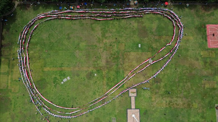 Foto udara peserta membentangkan bendera Merah Putih saat mengikuti Kirab Merah Putih di Lapangan Pancasila, Semarang, Jawa Tengah, Senin (10/11/2025). Kegiatan kirab dengan membentangkan bendera Merah Putih sepanjang 1.945 meter yang diikuti ribuan peserta dari kalangan guru, pelajar, mahasiswa, organisasi masyarakat, dan seniman di kota tersebut dalam rangka memperingati Hari Pahlawan 2025 sekaligus menumbuhkan jiwa nasionalisme dan kecintaan terhadap tanah air serta semangat patriotisme kepada generasi muda. ANTARA FOTO/Makna Zaezar