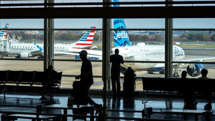 Travelers walk though Ronald Reagan Washington National Airport as the Trump administration warns of impending cuts to commercial airline operations more than a month into the continuing U.S. government shutdown in Arlington, Virginia, U.S., November 7, 2025. REUTERS/Nathan Howard