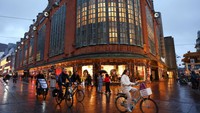 Orang-orang bersepeda melewati toko-toko di tengah Den Haag. REUTERS/Piroschka Van De Wouw