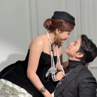 Jodie mengenakan dress beludru hitam tanpa lengan. Detail bunga putih di bagian bawah rok mempermanis tampilannya. Ia melengkapi gaya vintage-nya dengan topi kecil, sarung jaring, serta tumpukan kalung mutiara panjang yang menjuntai hingga dada. Foto: Instagram/@weddingstories.co