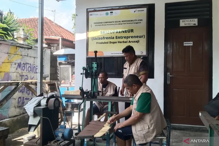 Dua orang dengan skizofrenia didampingi koordinator (tengah) memproduksi dupa di Rumah Berdaya Denpasar, Bali, Selasa (21/10/2025).