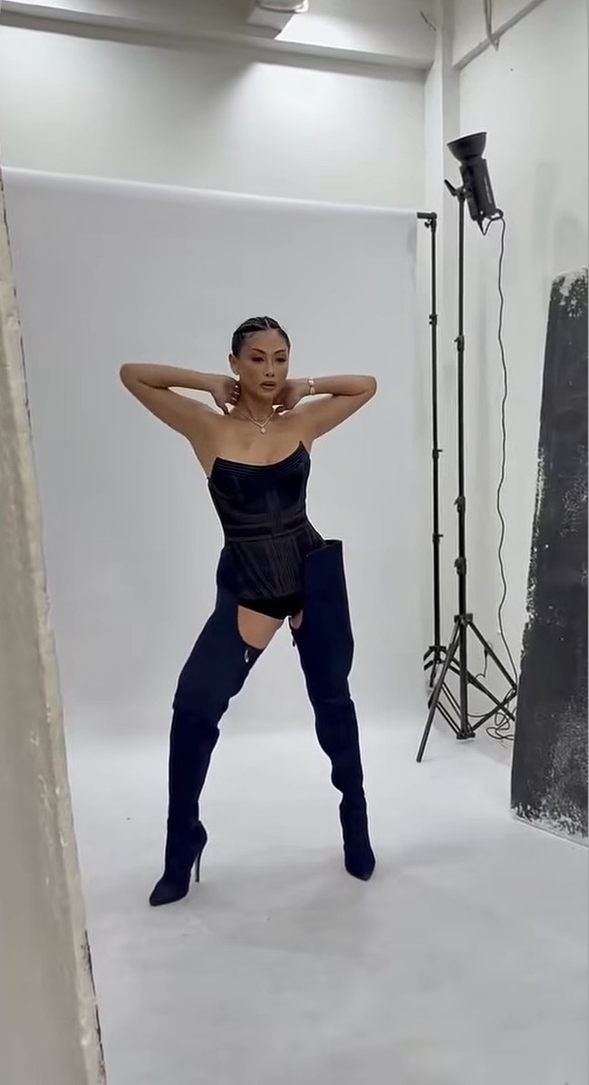 Sementara sang mama mengenakan bodysuit korset hitam model bustier yang memberi kesan ramping dan tegas. Ia kemudian memadukannya dengan thigh-high boots warna hitam. Foto: Instagram/@indahkalalo