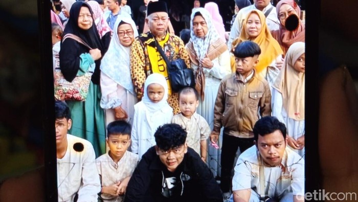 Istri Sugiyo, Siti Nurchayati (54) menunjukan momen foto bersama saat mengantarkan suaminya menuju Tanah Suci di Bandara Solo, Selasa (11/11/2025).