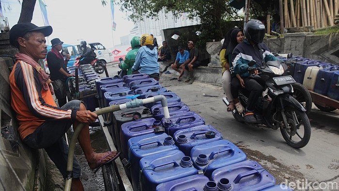 Penjual air keliling mengambil air bersih ke dalam jerigen di kios air bersih di Muara Angke, Jakarta Utara, Selasa (11/11/2025).
