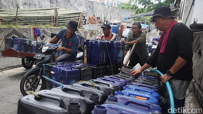 Penjual air keliling mengambil air bersih ke dalam jerigen di kios air bersih di Muara Angke, Jakarta Utara, Selasa (11/11/2025).
