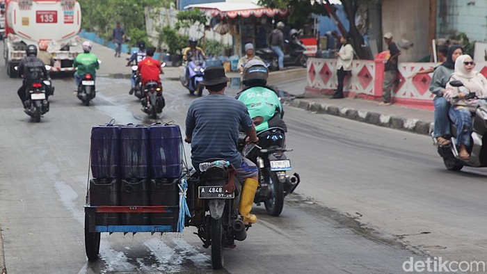 Penjual air keliling mengambil air bersih ke dalam jerigen di kios air bersih di Muara Angke, Jakarta Utara, Selasa (11/11/2025).