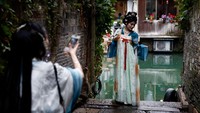 Seorang perempuan yang mengenakan kostum tradisional China berpose untuk difoto. Air adalah nadi kehidupan Wuzhen. Selain keindahan alamnya, Wuzhen juga menjadi saksi sejarah panjang budaya China — dari seni ukir kayu, arsitektur Ming dan Qing, hingga tradisi kuno yang masih dijaga penduduknya. Foto: REUTERS/Tingshu Wang