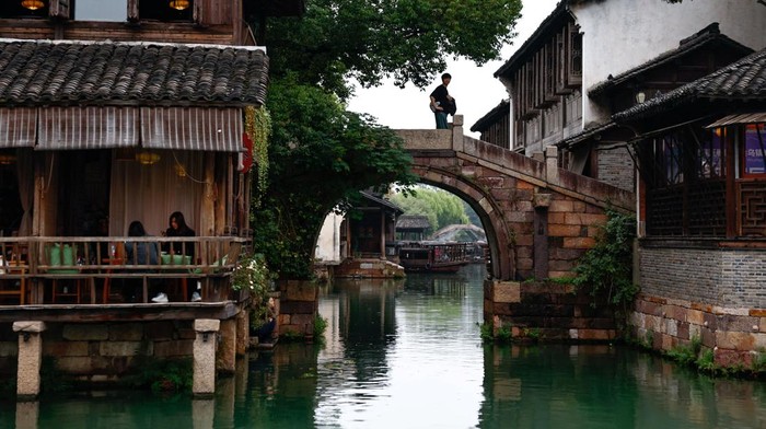 A person rides on a boat along a river at Wuzhen town of Tongxiang city, Zhejiang province, China November 8, 2025. REUTERS/Tingshu Wang