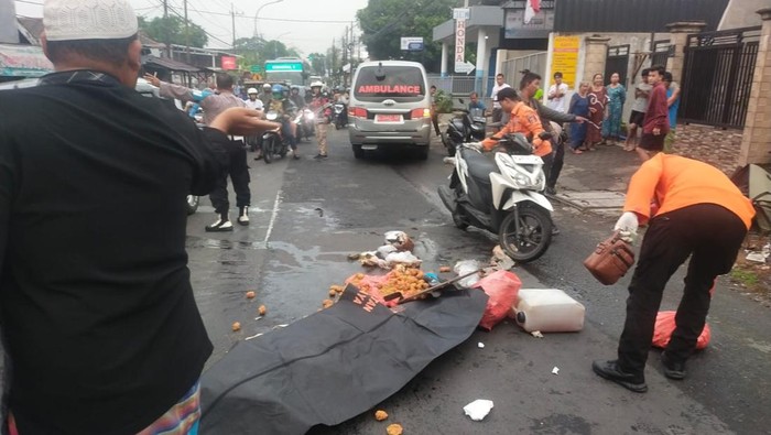 Petugas evakuasi jenazah pemotor yang tewas telrindas truk di Jalan Raya Jeruk Menganti, Surabaya
