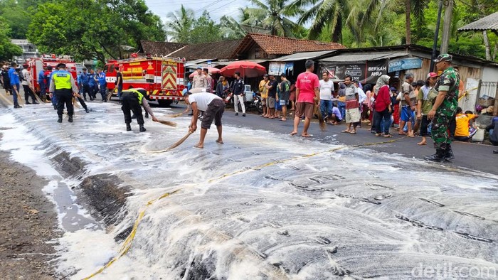 Petugas membersihkan jalan lokasi kecelakaan maut melibatkan truk tangki solar di Kalijambe, Purworejo, Selasa (11/11/2025).