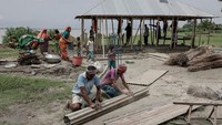 Keluarga Nabi membongkar rumah kayu mereka untuk dipindahkan ke pulau baru. Bagi warga char, memindahkan rumah adalah bagian dari hidup. REUTERS/Mohammad Ponir Hossain