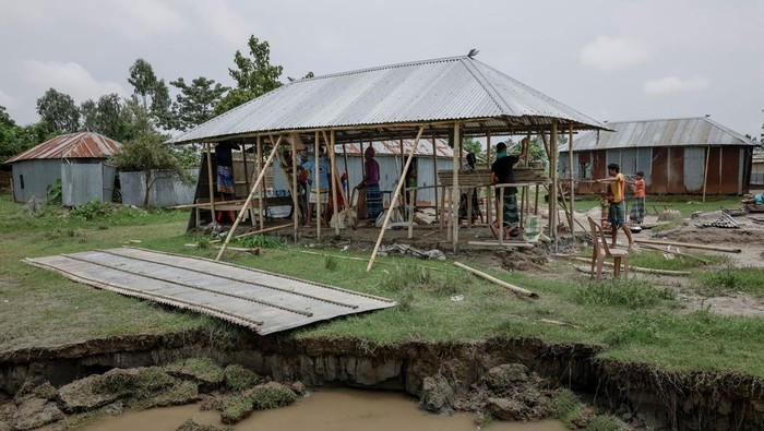 Relatives and neighbours help move the house of Kosim Uddin, 50, to another island on the Brahmaputra river, as the current one is about to be destroyed by erosion, in Kurigram, Bangladesh, June 20, 2024. REUTERS/Mohammad Ponir Hossain