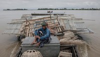 Warga berpindah pulau dengan perahu untuk membangun tempat tinggalnya kembali. Erosi bukanlah fenomena baru, tetapi penduduk setempat mengatakan bahwa sebelumnya char-char tersebut lebih menetap. Namun, curah hujan yang tidak sesuai musim dan perubahan kedalaman sungai telah mempercepat masalah ini. Faktor lainnya adalah urbanisasi yang berkontribusi pada peningkatan jumlah sedimen dan akibatnya, aliran di hilir. REUTERS/Mohammad Ponir Hossain