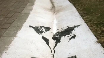 The world going down the drain karya Pejac. Seni jalanan ini dapat ditemui di Santander, Spanyol, menggambarkan dunia yang seolah terbuang ke selokan, menggambarkan ketergantungan kita pada bahan bakar fosil dan dampaknya terhadap lingkungan. Foto: via StreetArtUtopia