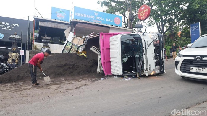 Truk pasir yang dikemudikan Suardika terguling melintang di persimpangan tanjakan GWK, Selasa (11/11/2025). (Aryo Mahendro/detikBali).