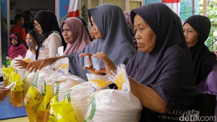 Warga mengambil bantuan pangan di Kantor RW 03, Jalan Menteng Sukabumi, Menteng, Jakarta, Rabu (12/11/2025).