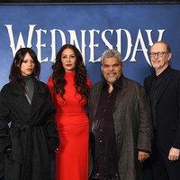 Catherine tampil memesona saat mempromosikan serial Wednesday. Dia mengenakan gaun turtleneck berpotongan ketat warna merah yang dipadukan dengan boots hitam. Foto: Getty Images for Netflix/Noam Galai