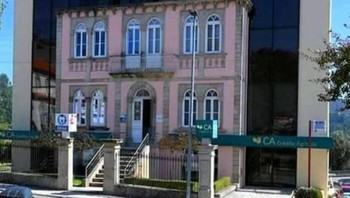 Gedung modern hitam besar di Portugal ini seolah menelan rumah mungil bergaya kolonial pink di depannya. Foto: Boredpanda