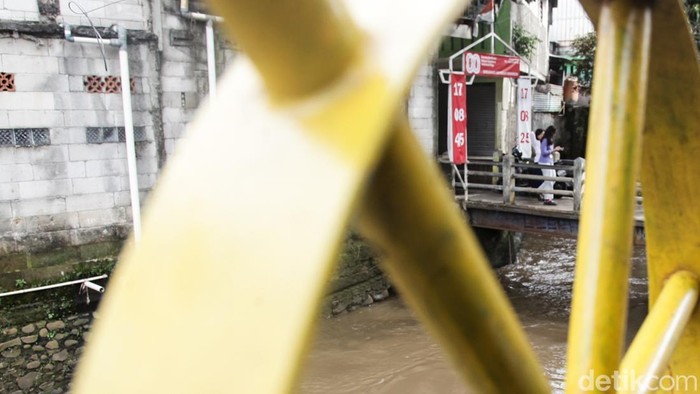 Warga melintas di atas jembatan Kali Krukut di Petogogan, Jaksel, Rabu (12/11/2025). Gubernur DKI Jakarta Pramono Anung akan menormalisasi Kali Krukut. Pramono menyebut luapan Kali Krukut bisa menyebabkan banjir sampai ke wilayah Kemang.