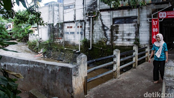 Warga melintas di atas jembatan Kali Krukut di Petogogan, Jaksel, Rabu (12/11/2025). Gubernur DKI Jakarta Pramono Anung akan menormalisasi Kali Krukut. Pramono menyebut luapan Kali Krukut bisa menyebabkan banjir sampai ke wilayah Kemang.
